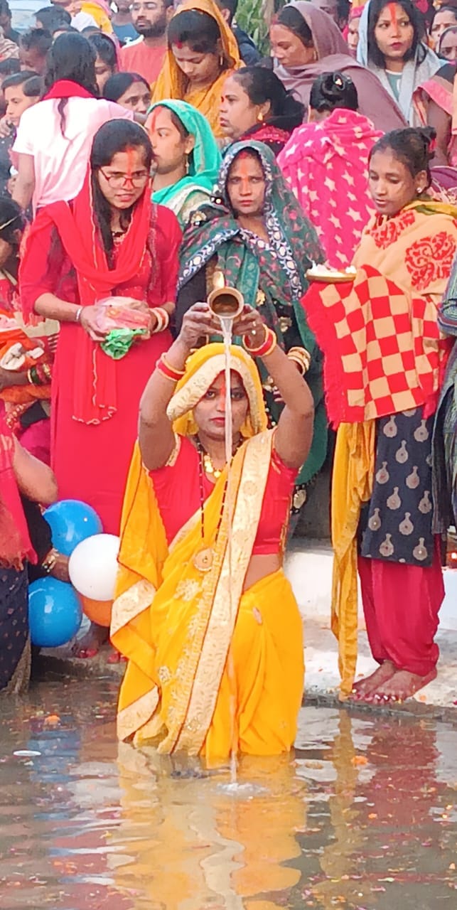 बरहा रेलवे क्रांसिग के पास स्थित सरोवर पर छठ पूजा के दौरान सरोवर में खड़ी महिलाएं । संवाद