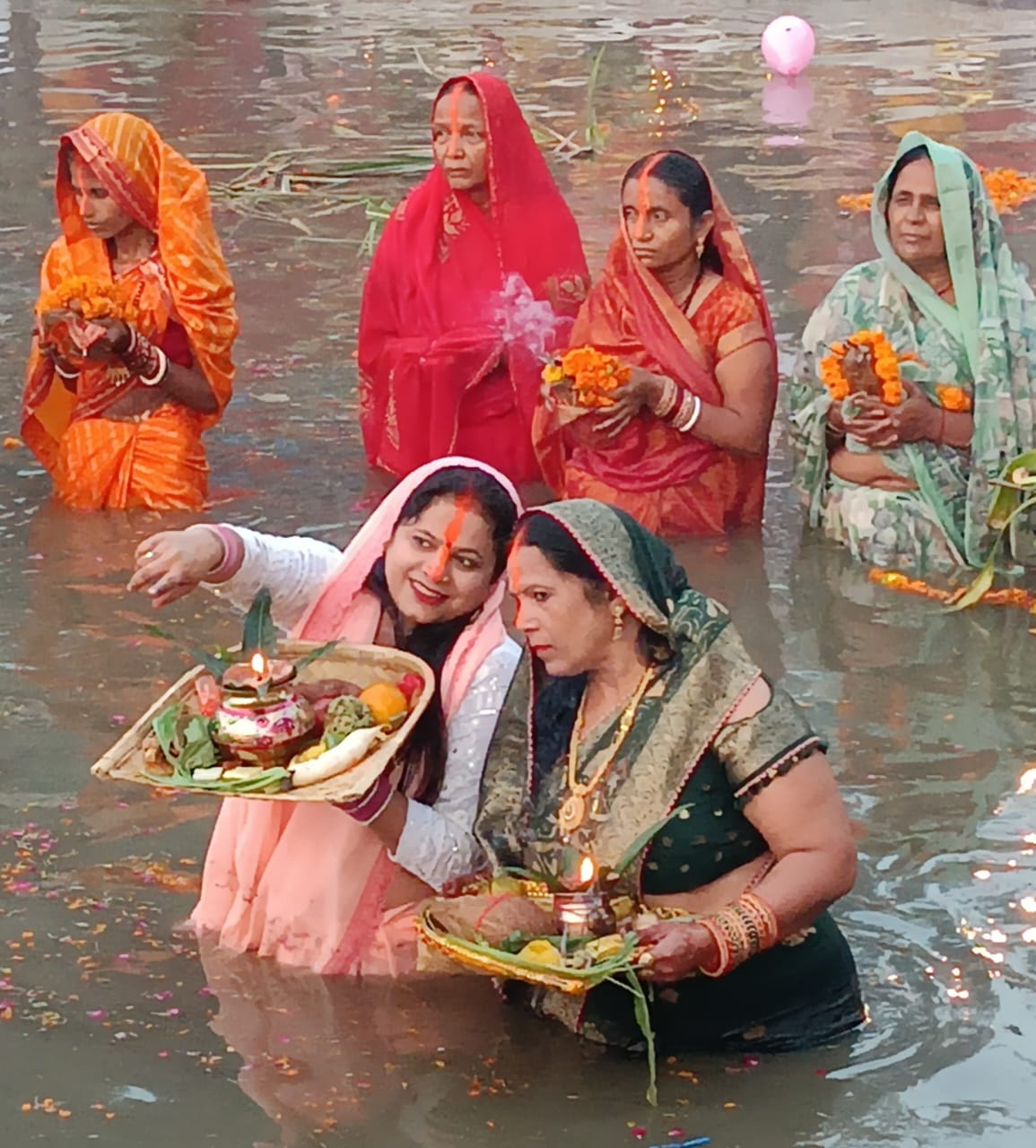 बरहा रेलवे क्रांसिग के पास स्थित सरोवर पर छठ पूजा के दौरान सरोवर में खड़ी महिलाएं । संवाद