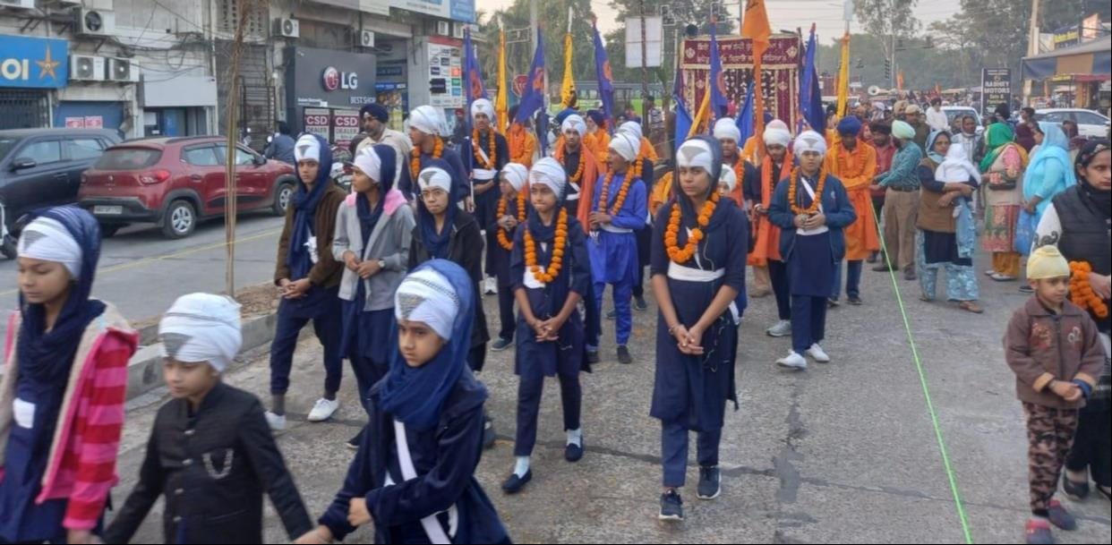 फूलों से सुसज्जित धन-धन श्री गुरु ग्रंथ साहिब जी महाराज का स्वरुप। संवाद