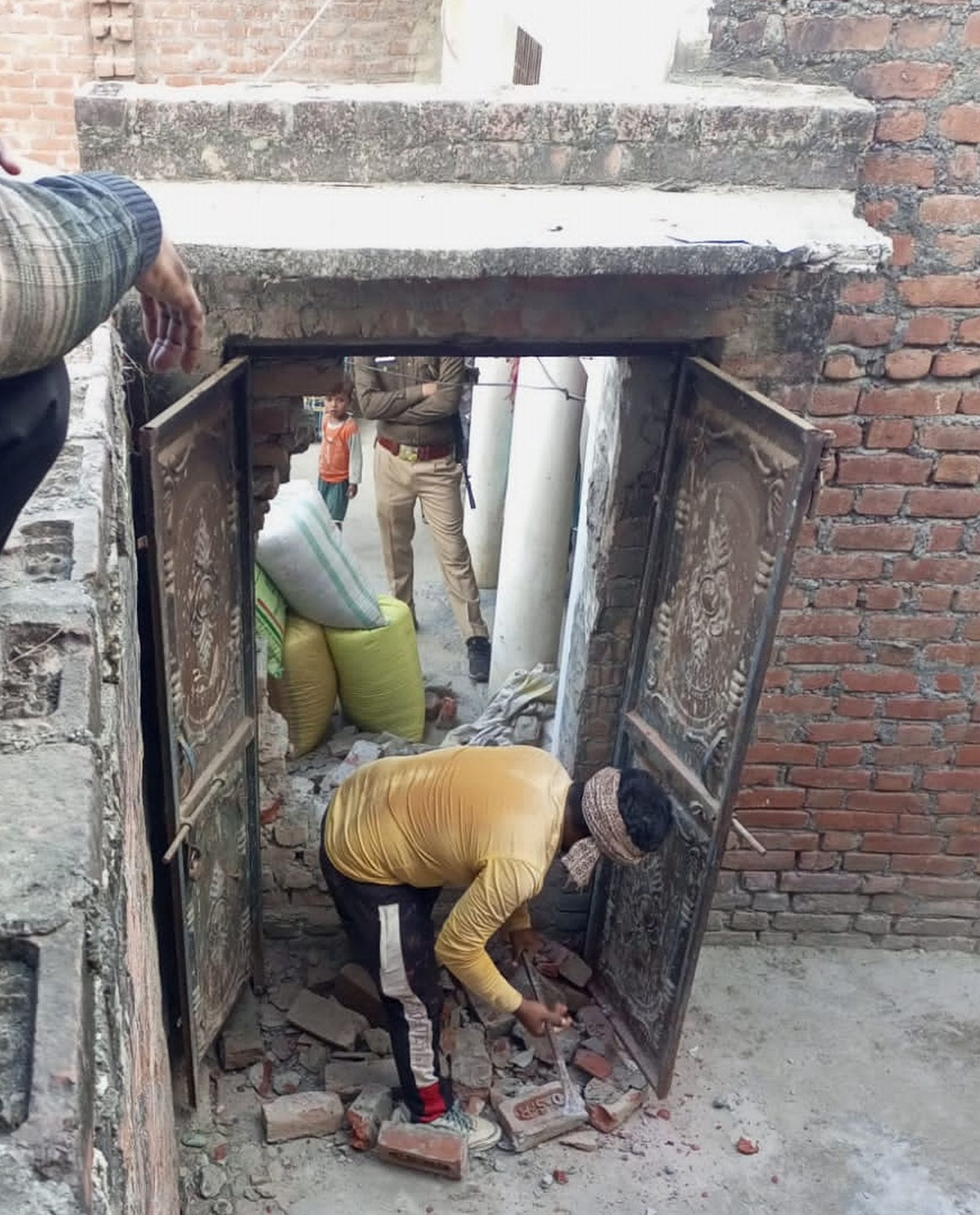 पड़ौलिया गांव में दरवाजे के आगे लगी दीवार तुड़वाती पुलिस। संवाद पड़ौलिया गांव में दरवाजे के आगे लगी दीवार तुड़वाती पुलिस। संवाद