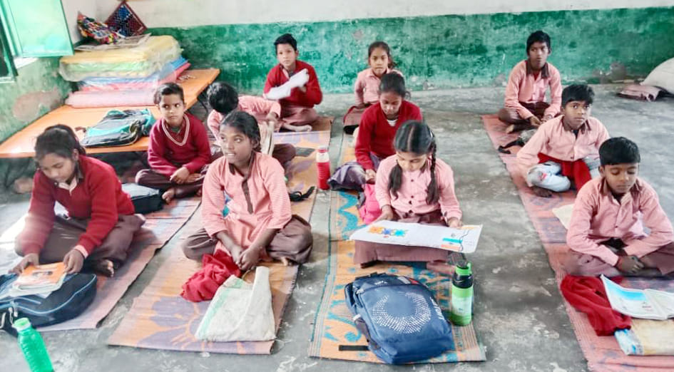 गोला के त्रिलोक गिरी सम्मेलन विद्यालय में चटाई पर बैठकर पढ़ते विद्यार्थी।