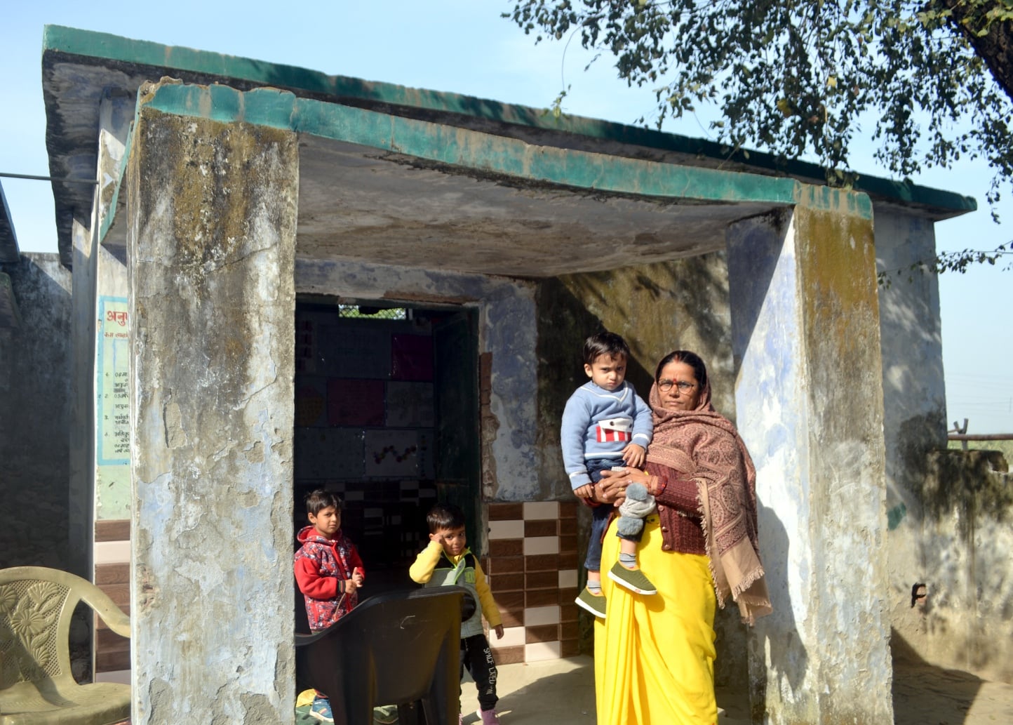 शामली क्षेत्र के गांव हसनपुर में    आँगनवाडी  केंद्र में  टूटे फर्स के बारे में जानकारी देते आं