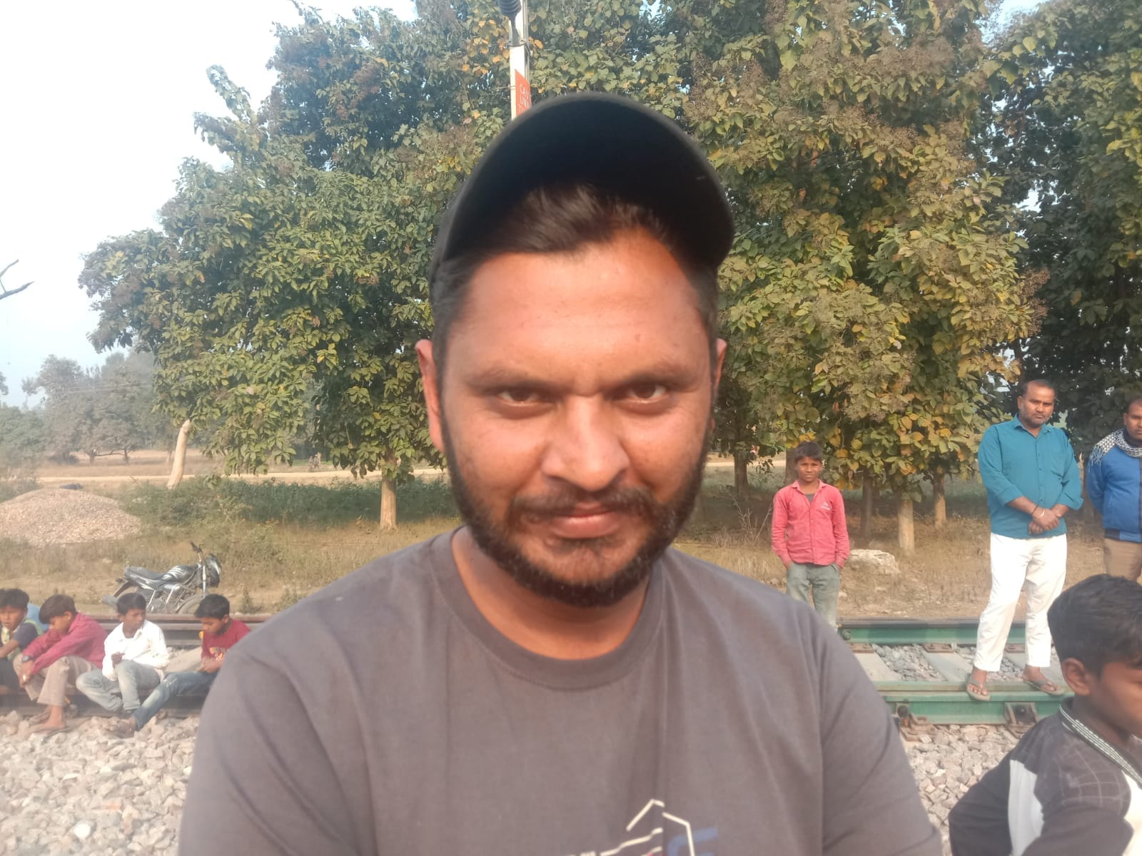 पूरनपुर क्षेत्र के दुधिया खुर्द रेलवे स्टेशन पर ट्रेन के आगे बैठकर प्रदर्शन करते लोग । संवाद