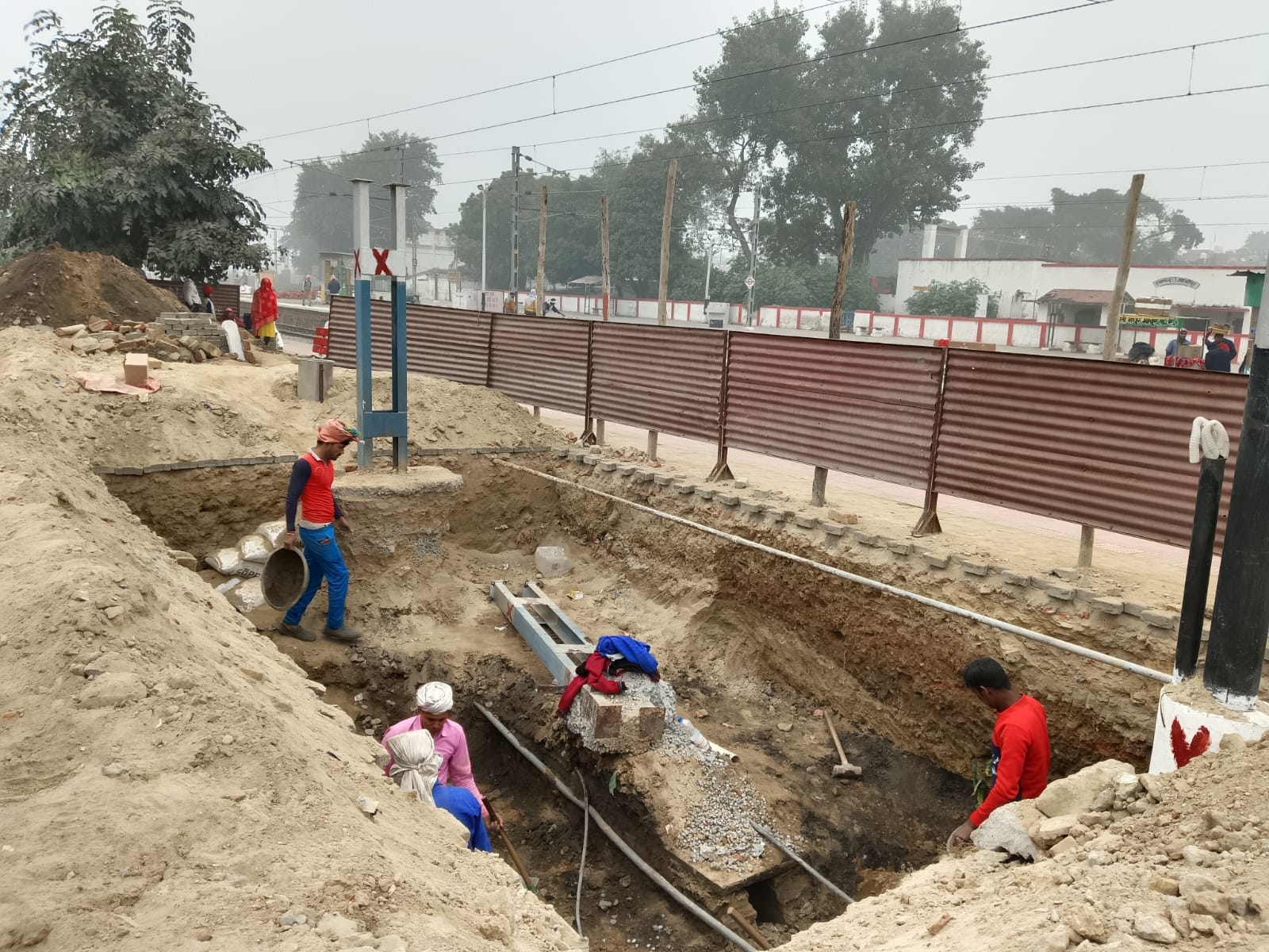 शाहजहांपुर रेलवे स्टेशन के प्लेटफार्म नंबर चार पर टिनशेड न होने से खुले आसमान के नीचे खड़े यात्