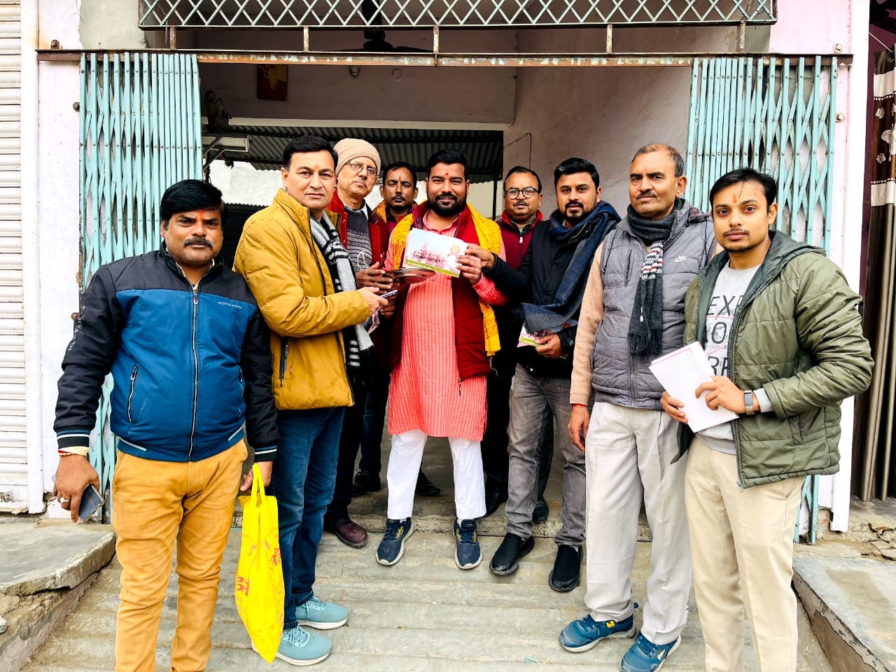 तिलहर के गांव सुरेली में संघ कार्यकर्ता ग्रामीणों को अक्षत और पत्रक वितरित करते हुए