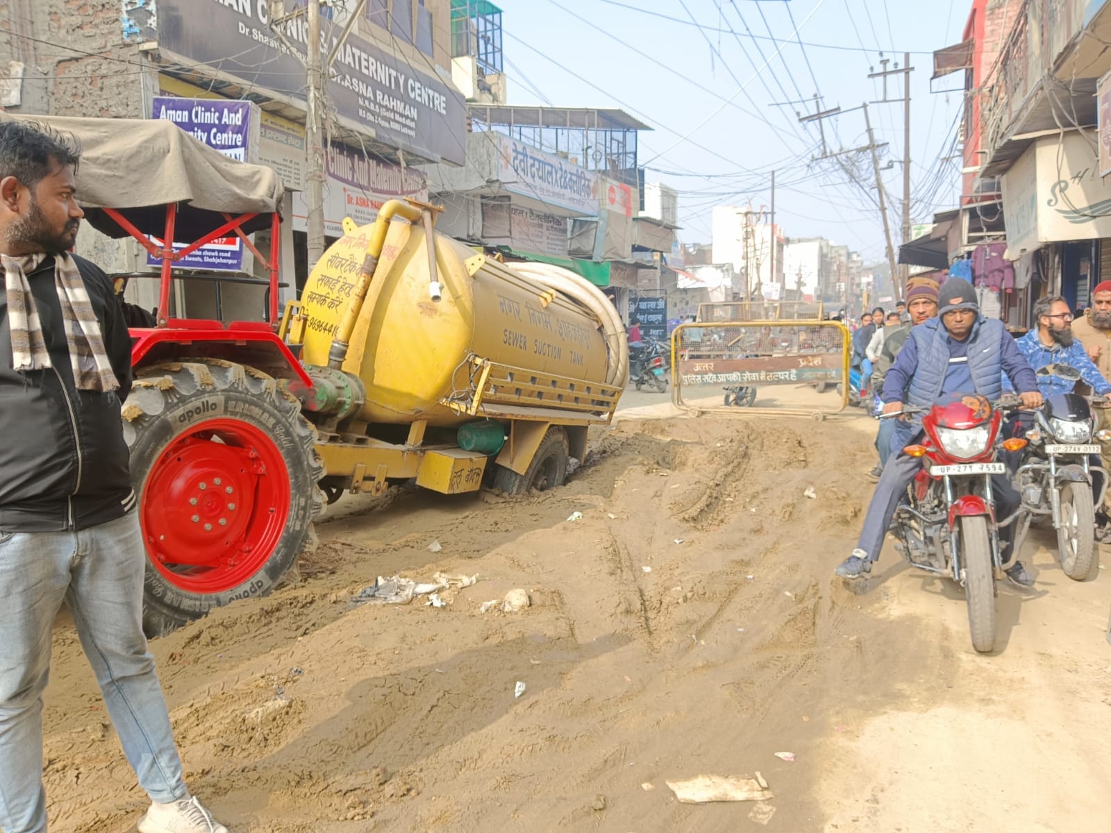 शहर के चारखंभा पर सीवर लाइन के खोदी गई सड़क में फंसा नगर निगम का टैंकर व किनारे से निकलने का प्