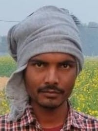 ठंड से बचाने के लिए बच्चे को गर्म कपड़े में लपेट कर ले जाता व्यक्ति। संवाद