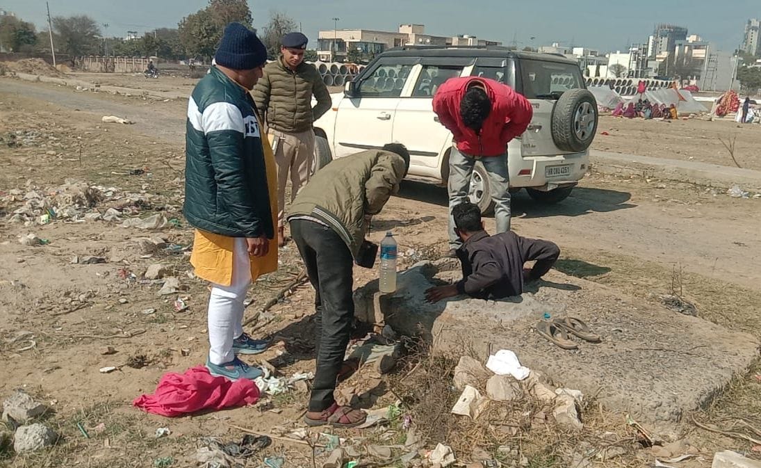 09जेएनडी41: सीवर में बच्चे की तलाश करते हुए परिजन व पुलिस। स्त्रोत।