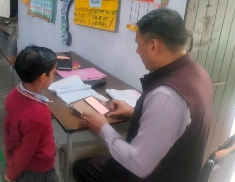 17जेएनडी10-बच्चे से प्रश्र पूछते जिला नोडल अधिकारी राजेश वशिष्ठ। स्वयं