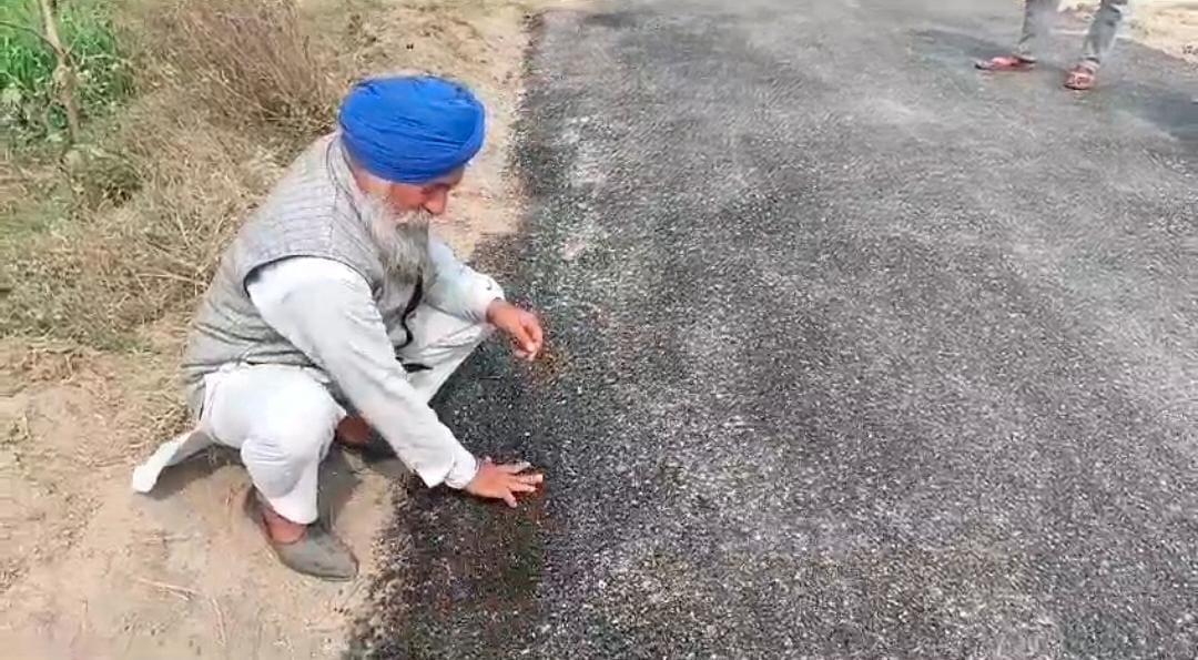 झाडू से बजरी हटाता ग्रामीण । स्रोत - वायरल वीडियो