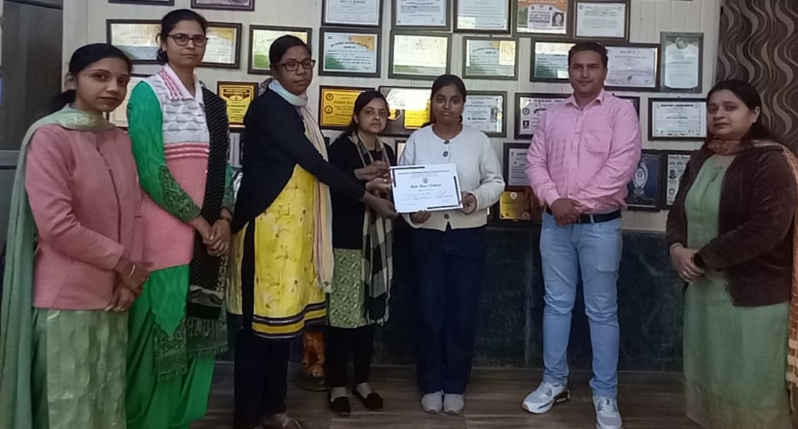 प्रतियोगिता में छात्राओं द्वारा बनाए गए मॉडल देखते स्टाफ सदस्य।