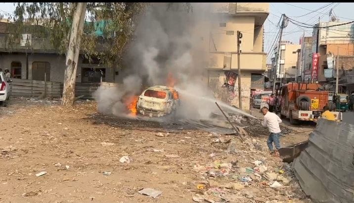 सोनीपत में कपड़ा मार्केट के सामने पार्किंग में खड़ी कार में लगी आग पर काबू पाने का प्रयास करती 