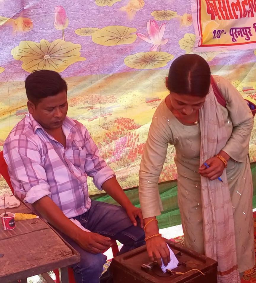 वोटर लिस्ट में अपना नाम देखते मतदान कर्मी । संवाद वोटर लिस्ट में अपना नाम देखते मतदान कर्मी । संवाद