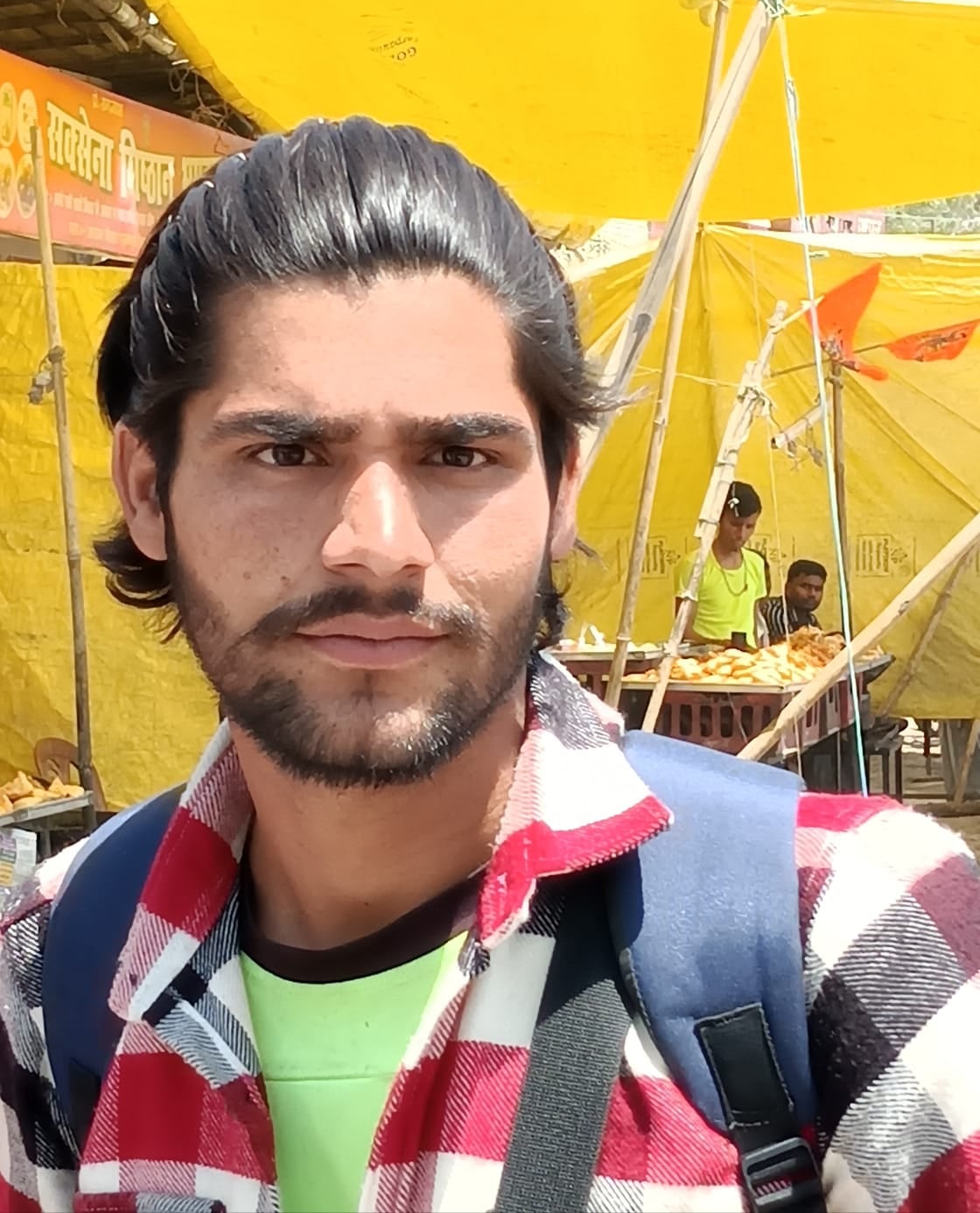 शहर के असम चौराहे के पास पूरनपुर मार्ग पर वाहन के इंतजार में खड़े लोग । संवाद
