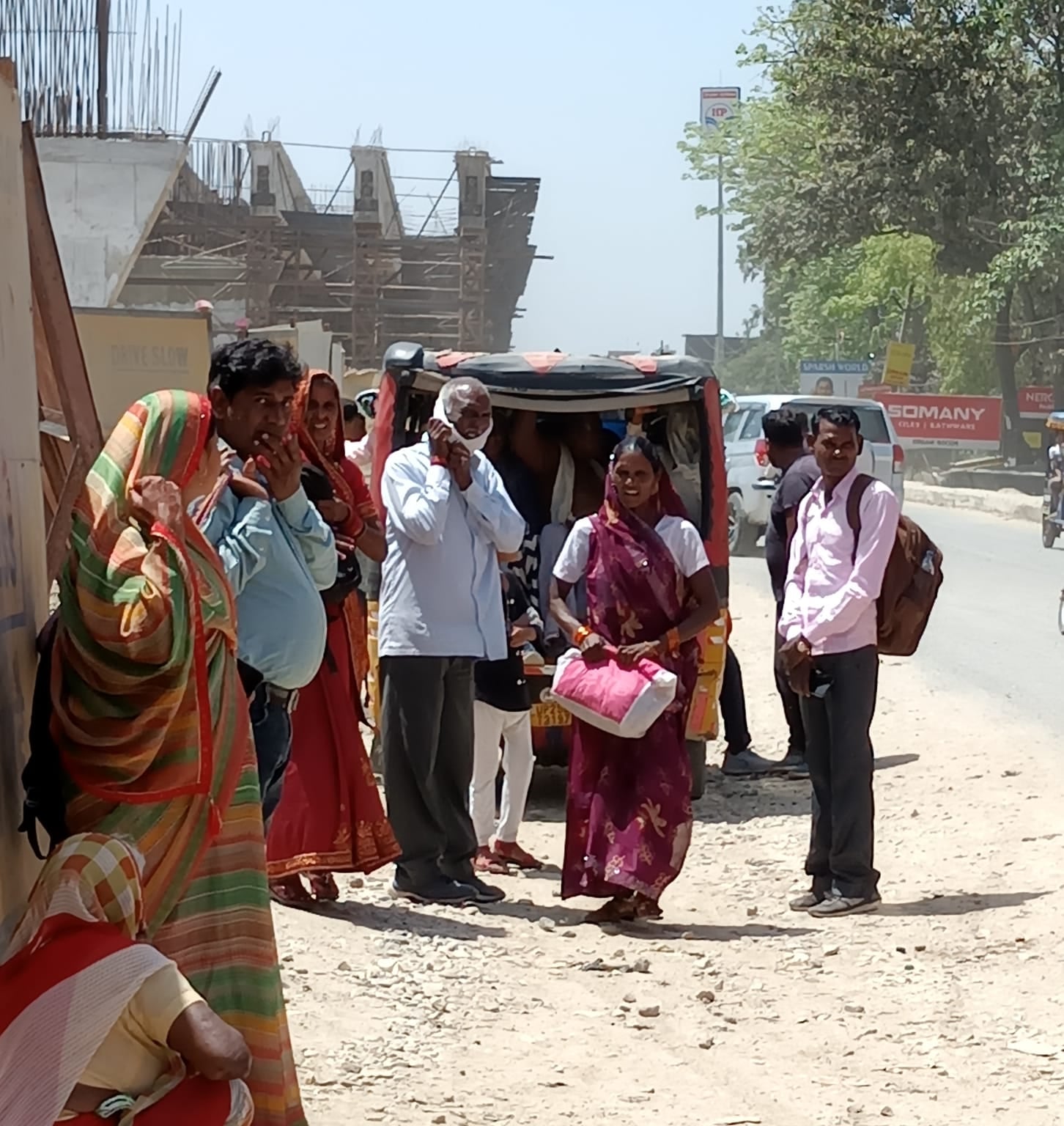 शहर के असम चौराहे के पास पूरनपुर मार्ग पर वाहन के इंतजार में खड़े लोग । संवाद