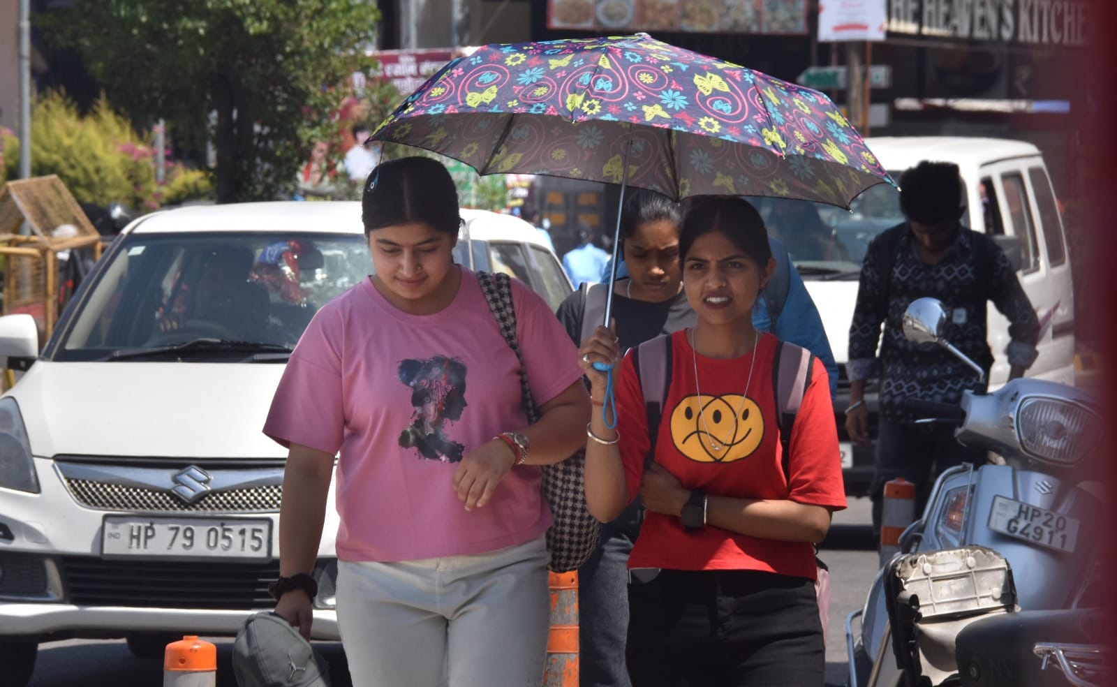 ऊना में गर्मी के बीच छाता लेकर गंतव्य की ओर जाती महिलाएं। संवाद