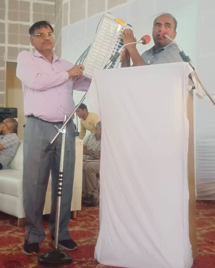 27जेएनडी04: चुनाव कर्मियों को ईवीएम मशीन का लाइव डैमो देते हुए ट्रेनर्स। संवाद