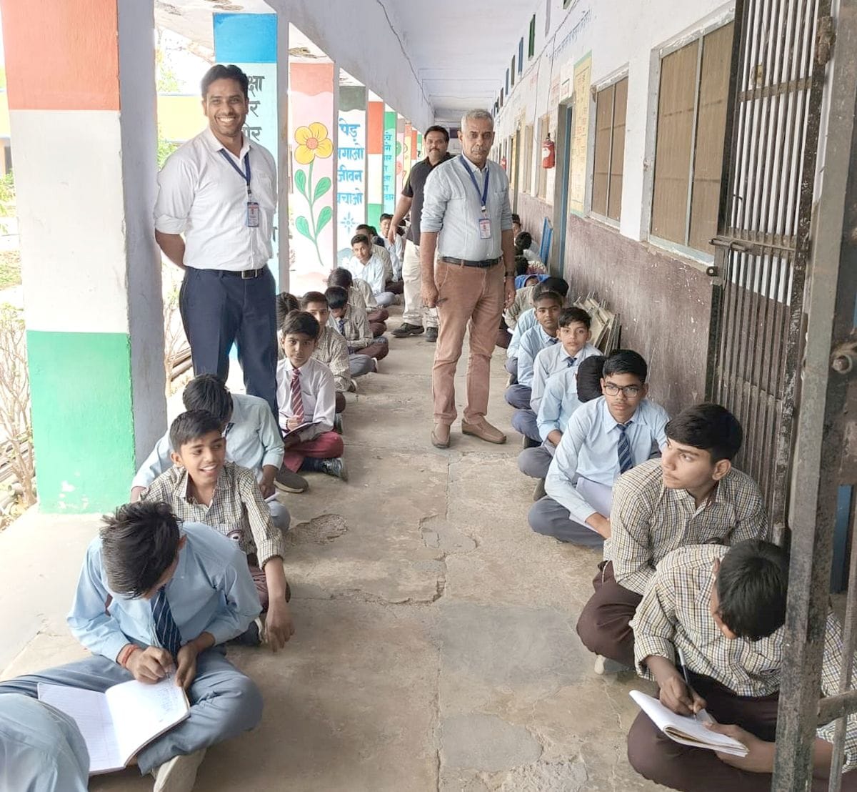 27जेएनडी31: 20 अप्रैल को जमीन पर बैठकर परीक्षा देते हुए बच्चे। संवाद
