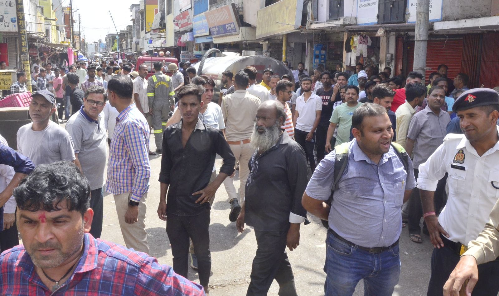 दुकान के अंदर लगी आग के बीच सामान निकालते दुकानदार। संवाद दुकान के अंदर लगी आग के बीच सामान निकालते दुकानदार। संवाद