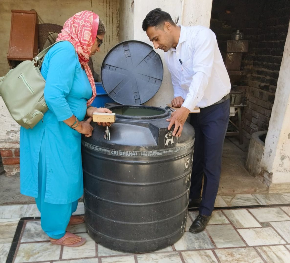 02जेएनडी01: घर में रखी पानी की टंकी की जांच करते हुए स्वास्थ्यकर्मी। संवाद