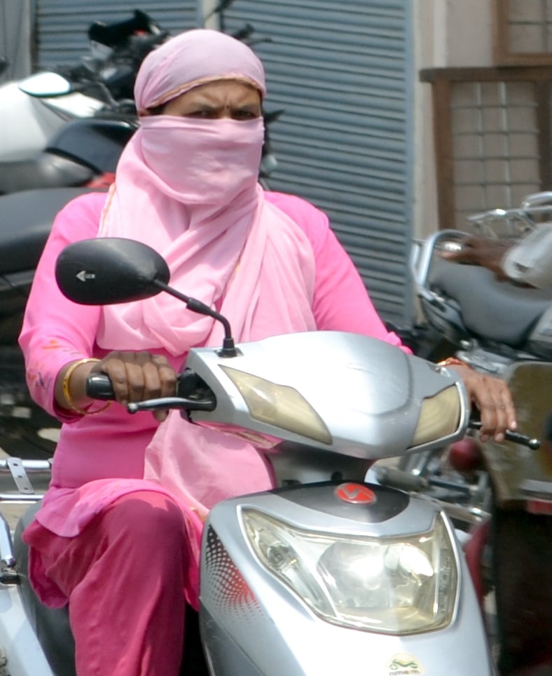 धूप से बचने के लिये कपडा लपेट कर जाती युवतिया