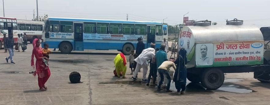 10जेएनडी10-बस अड्डे पर समाजसेवी द्वारा रखवाए गए वाटर टैंक से पानी पीते यात्री। संवाद