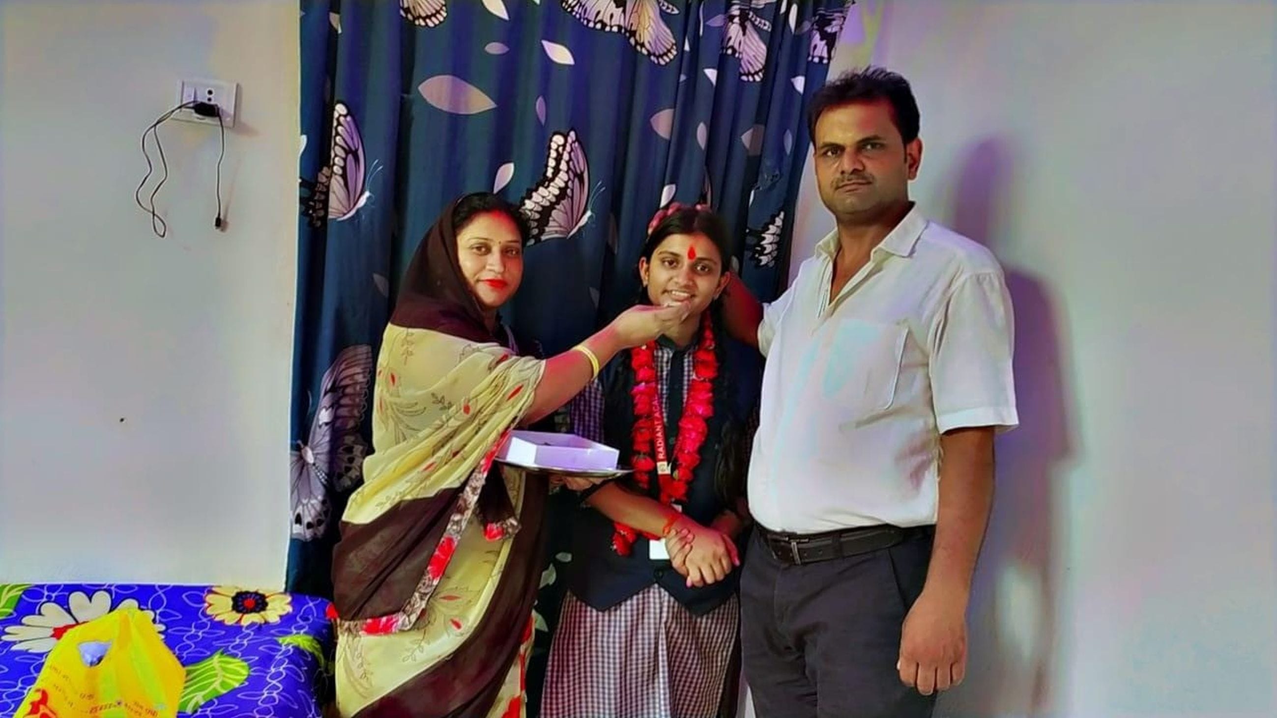 पिता की मौजूदगी उत्कर्ष को माला पहनाकर सम्मानित करते प्रधानाचार्य व अन्य। 