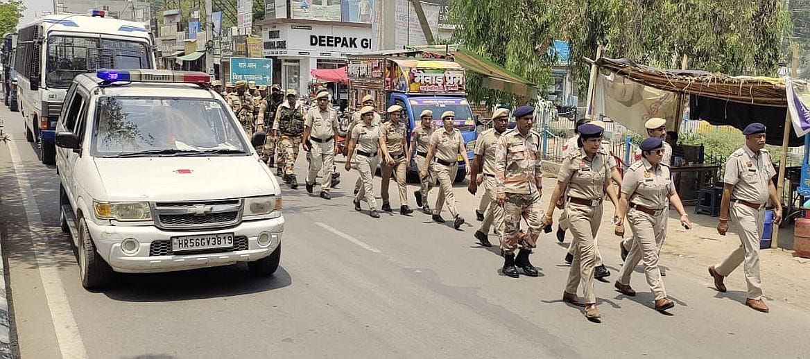 16जेएनडी28: शहर में फ्लैग मार्च निकालते हुए पुलिस व पैरामिल्ट्री के जवान। संवाद