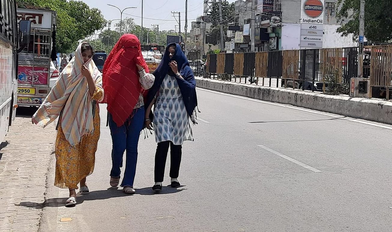 17जेएनडी12 : तेज धूप के बीच सड़क से गुजरती छात्राएं। संवाद