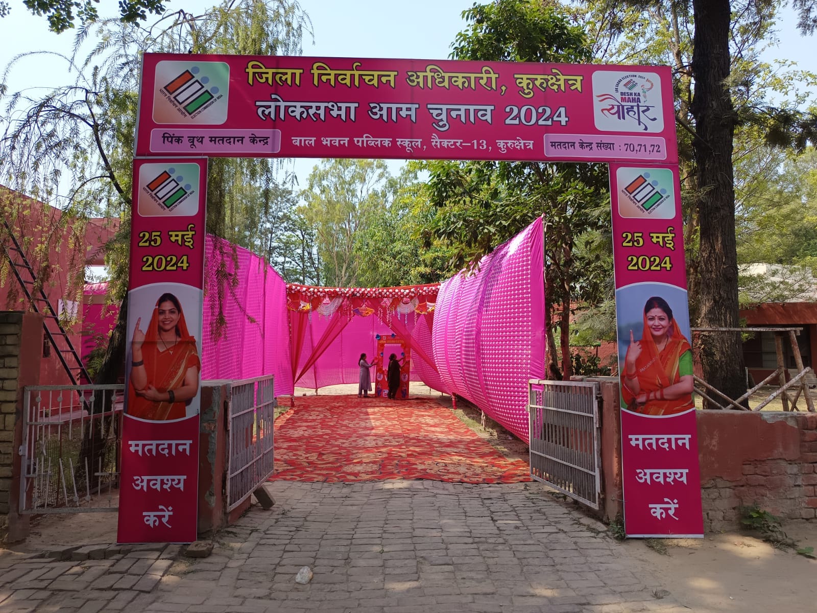 कुरुक्षेत्र। पिंक बूथ पर पिंक रंग से रंगोली बनाती हुई कर्मचारी। संवाद कुरुक्षेत्र। पिंक बूथ पर पिंक रंग से रंगोली बनाती हुई कर्मचारी। संवाद