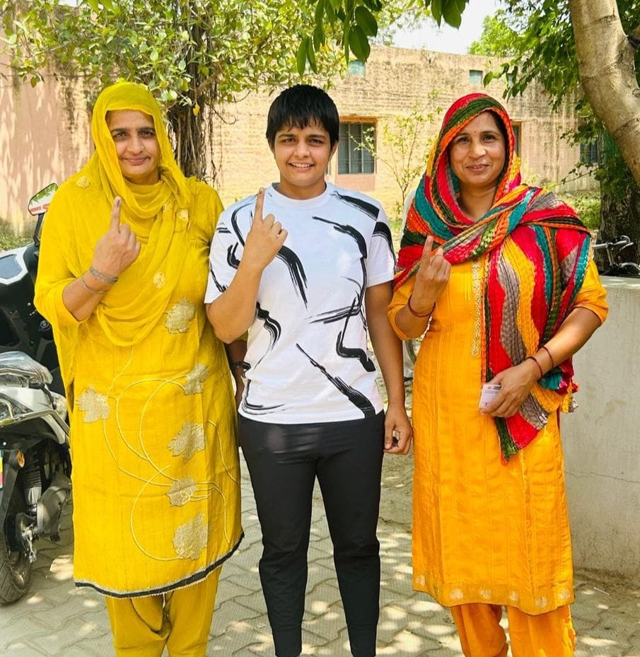  सोनीपत के गांव भैंसवाल कलां में ग्रामीणों के साथ वोट डालने के बाद उंगली पर लगी स्याही दिखाते भ