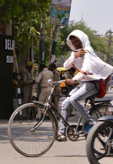 बृहस्पतिवार की दोपहर तेज धूप व र्मी से बचाव कर जाते लोग । संवाद