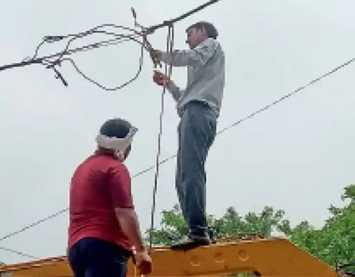 01जेएनडी26 : बिजली के फॉल्ट ठीक करते बिजली निगम कर्मचारी। संवाद