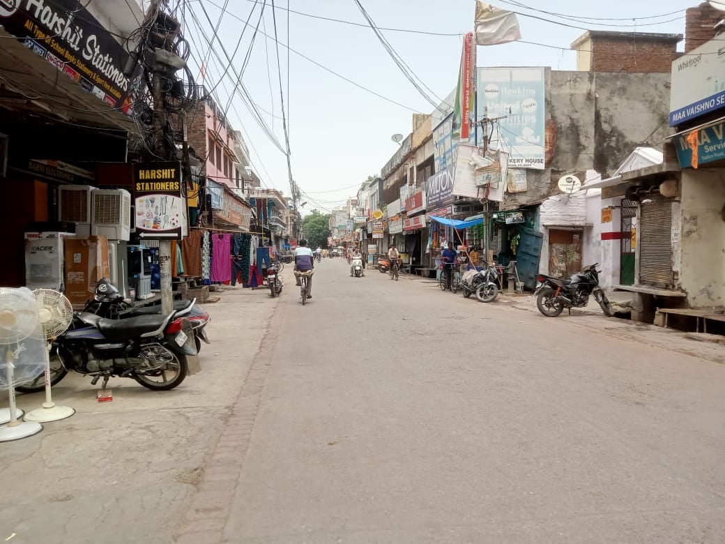 शहर के बाजार में एक दुकान पर टीवी पर चुनाव के नतीजे देखते लोग । संवाद