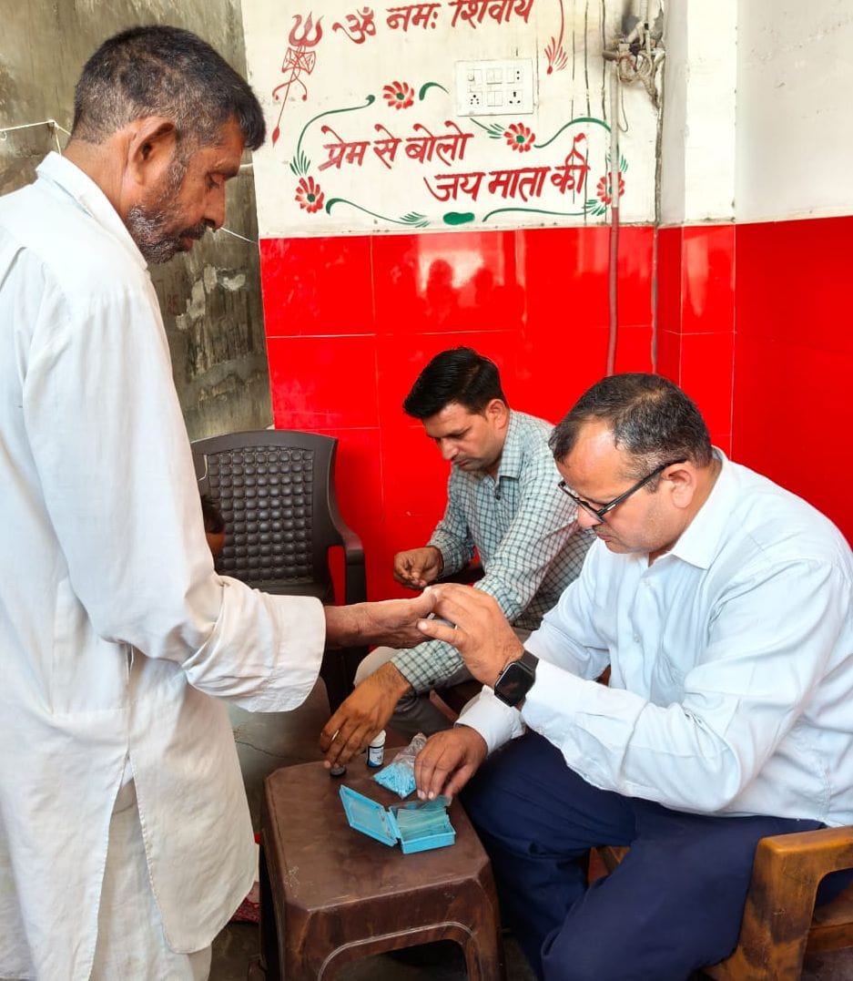 22जेएनडी04 : एक घर के बाहर रखे पानी के बर्तन में डेंगू के लार्वा की जांच करते स्वास्थ्य कर्मचार