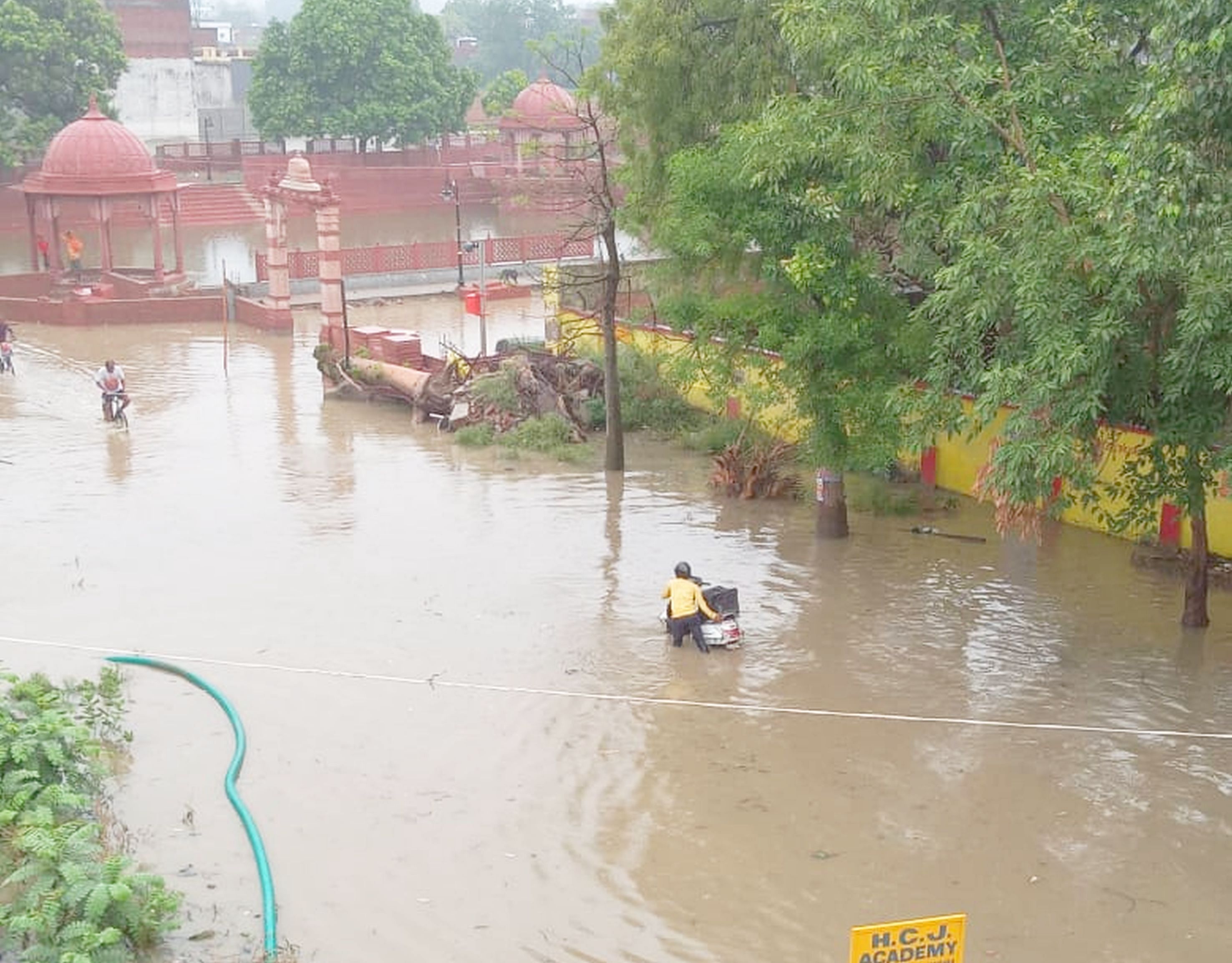 Saints and others passing through the waterlogging caused by rain water in Jalwanpura. 