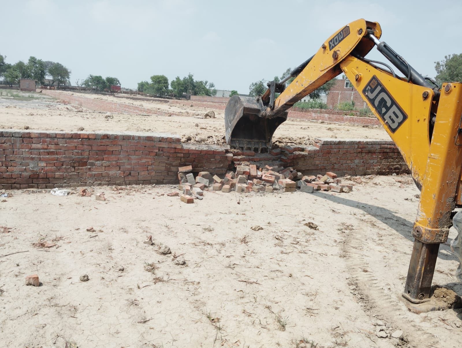 29जेएनडी13 : अवैध रुप से कॉलोनी विकसित करने के लिए बनाई गई दीवार को गिराती प्रशासन की जेसीबी। स 29जेएनडी13 : अवैध रुप से कॉलोनी विकसित करने के लिए बनाई गई दीवार को गिराती प्रशासन की जेसीबी। स