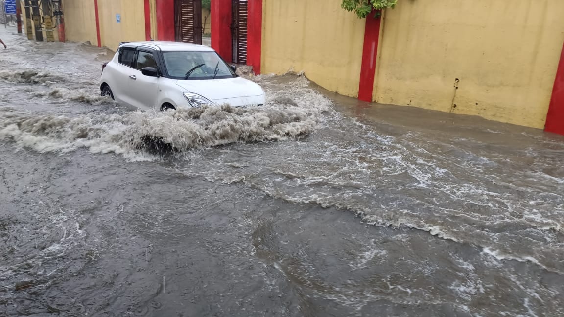 फोटो 31- सोनीपत के गन्नौर में हुई बारिश के बाद रेलवे रोड पर भरे पानी से गुजरते वाहन। संवाद