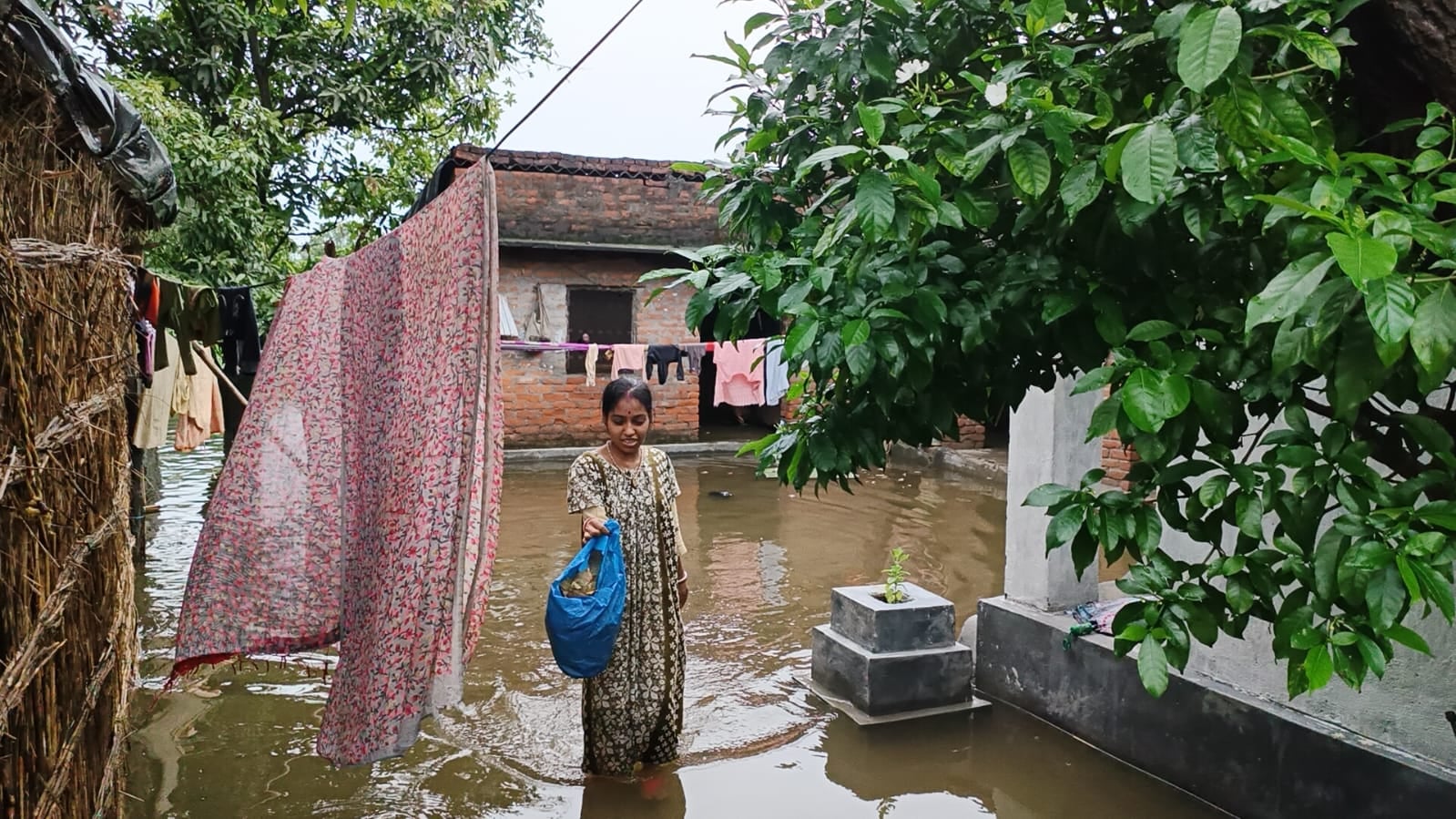 कलीनगर के गांव कंजियासिंहपुर में बाढ़ के बीच मासूम बच्चे को गोद में लेकर सुरक्षित स्थान पर जात