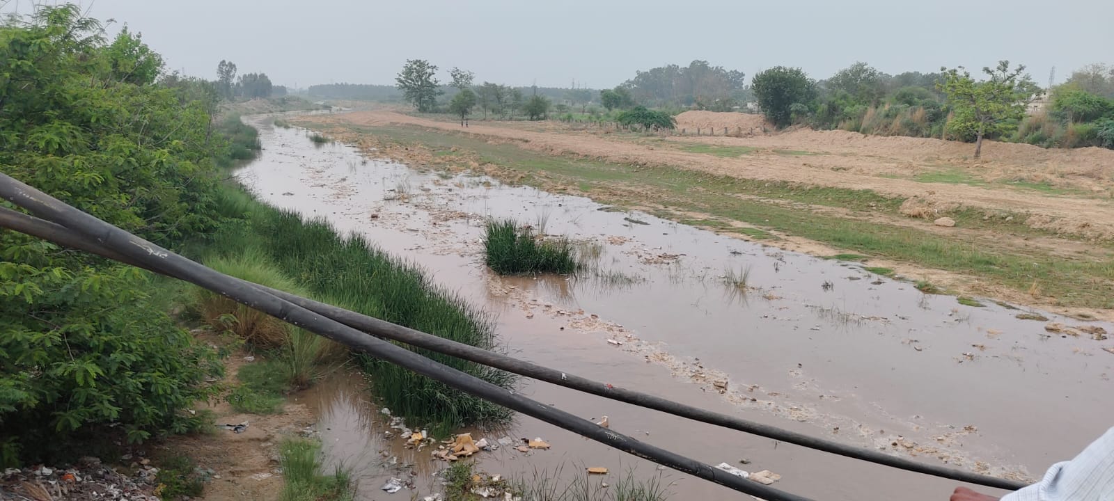 टांगरी नदी में आए पानी को देखते स्थानीय निवासी। संवाद टांगरी नदी में आए पानी को देखते स्थानीय निवासी। संवाद