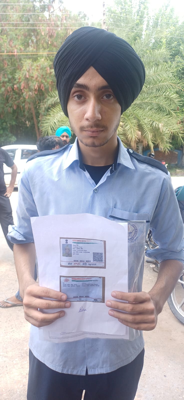 स्कूल के बाहर खडे़ परिक्षार्थी आधार कार्ड की कॉपी दिखाते हुए।