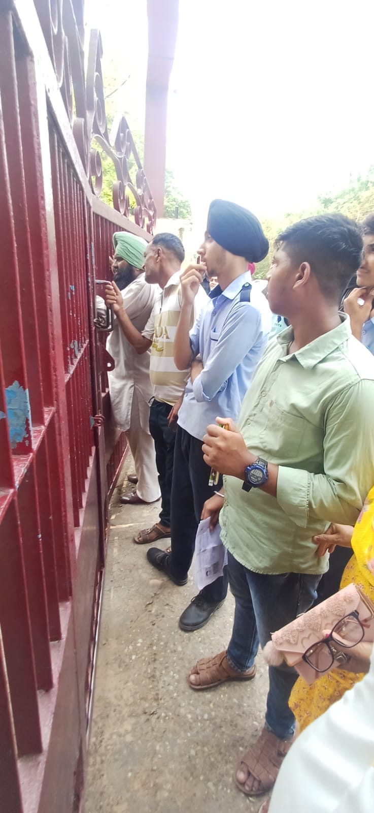 स्कूल के बाहर खडे़ परिक्षार्थी आधार कार्ड की कॉपी दिखाते हुए।