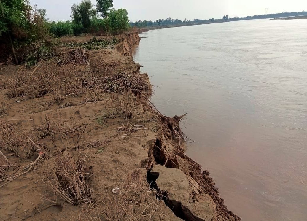 टूटी नाव से नदी पार करते परौर के लोग। संवाद