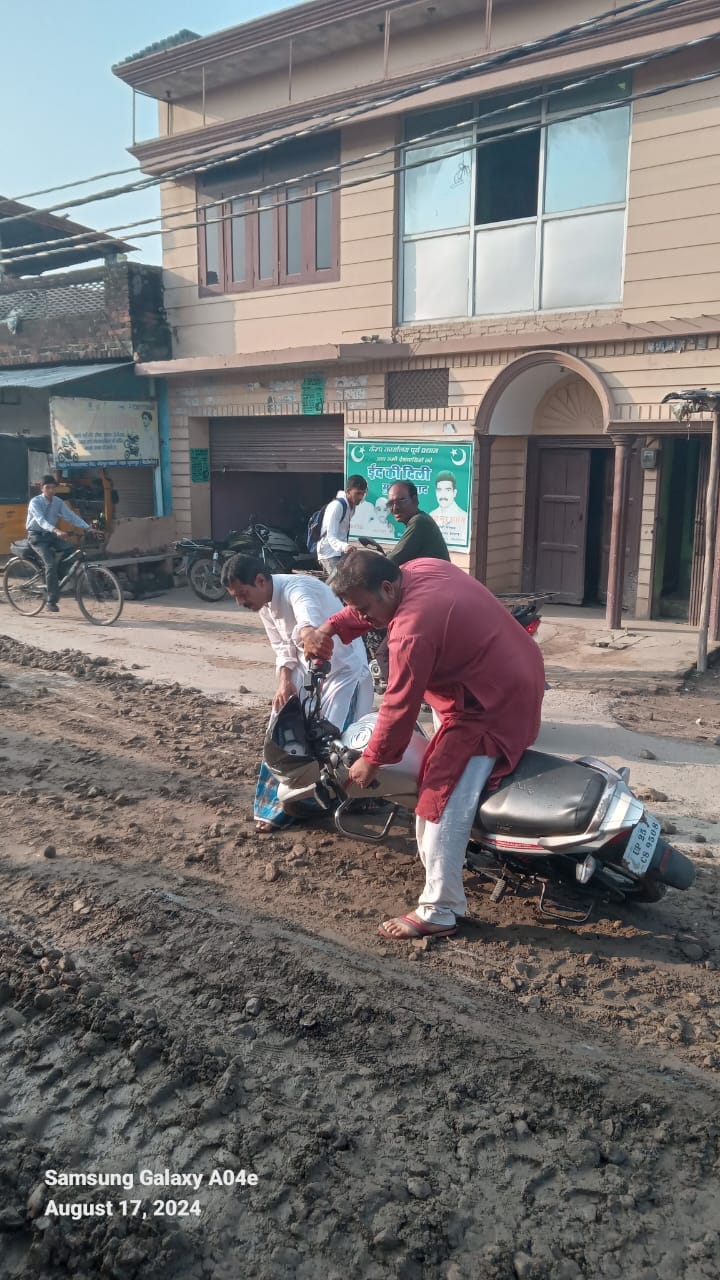 माधोटांडा मार्ग से धनाराघाट जाने वाली खोदी गई सड़क पर भरा पानी।संवाद