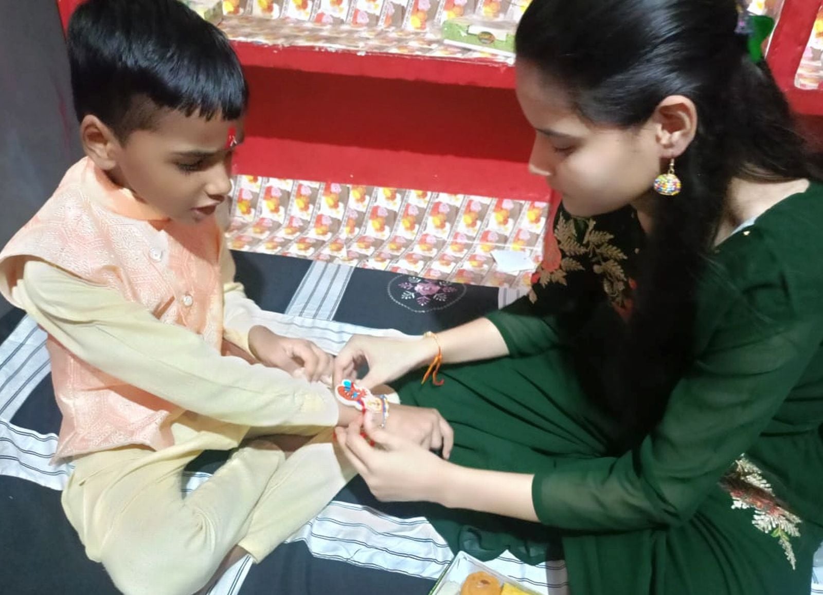 बिल्सी में अपने भाई को राखी बांधती बहन। संवाद