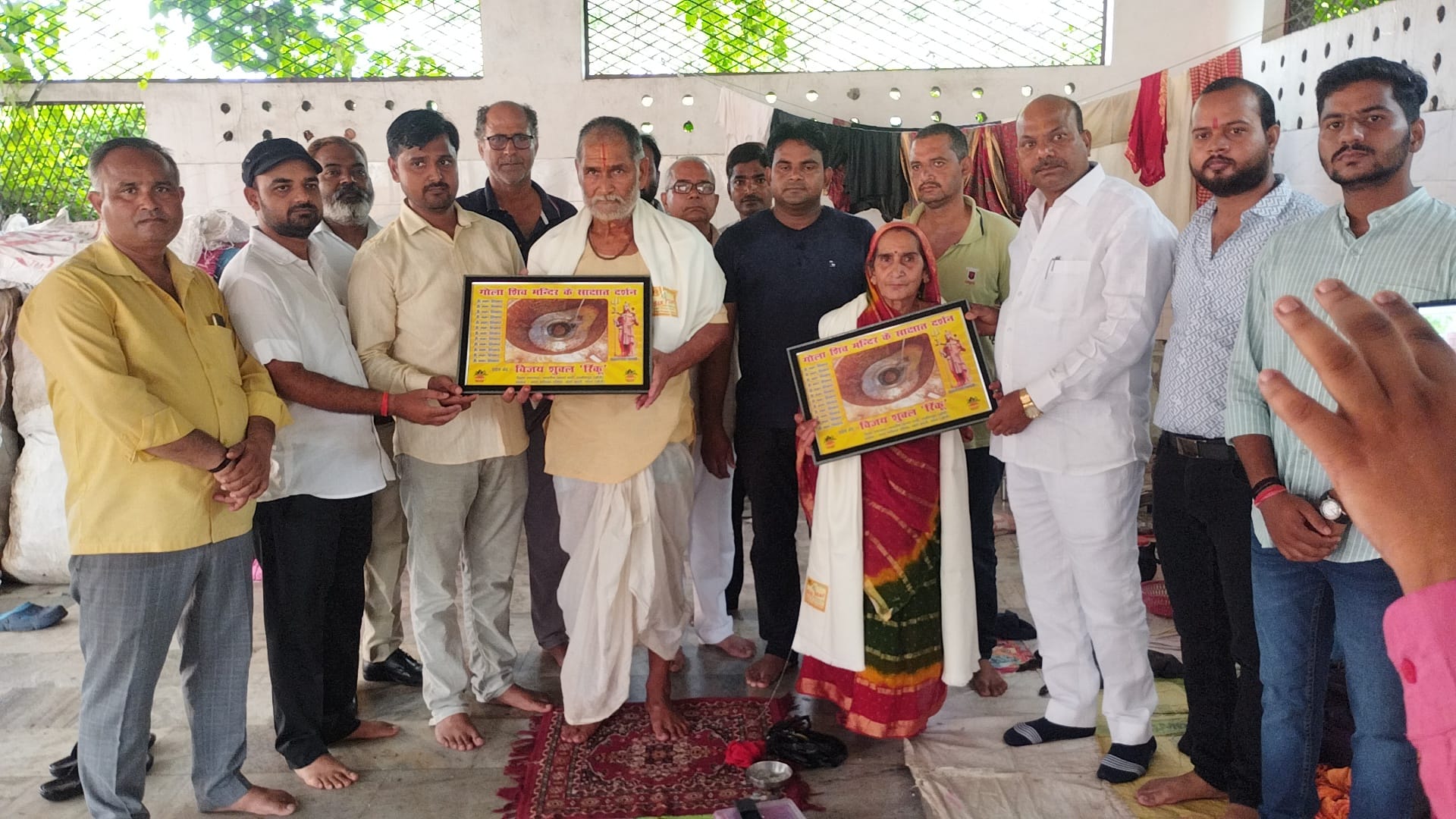 गोला में पौराणिक शिव मंदिर के गर्भ ग्रह के बाहर फूलों की थाली लिए खड़े शिव भक्त। संवाद गोला में पौराणिक शिव मंदिर के गर्भ ग्रह के बाहर फूलों की थाली लिए खड़े शिव भक्त। संवाद