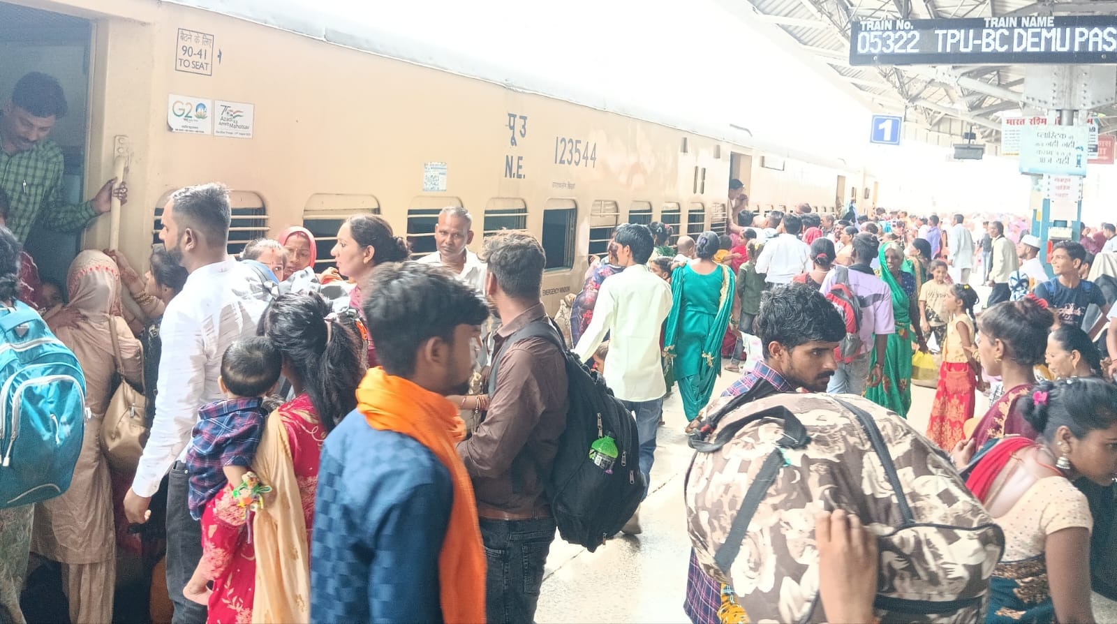 पीलीभीत के रेलवे जंक्शन पर ट्रेन की खिड़की से बच्चे को चढ़ाता यात्री।संवाद