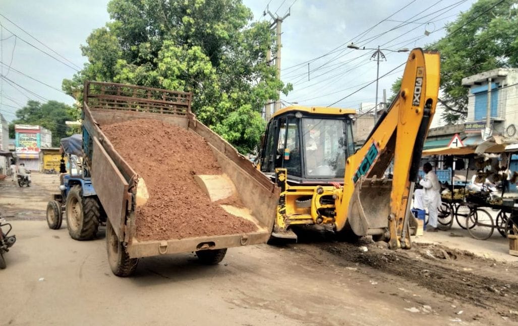 फोटो संख्या:70- बालाजी चौक पर ट्रॉली के माध्यम से रोड़े डालते कर्मचारी--संवाद फोटो संख्या:70- बालाजी चौक पर ट्रॉली के माध्यम से रोड़े डालते कर्मचारी--संवाद