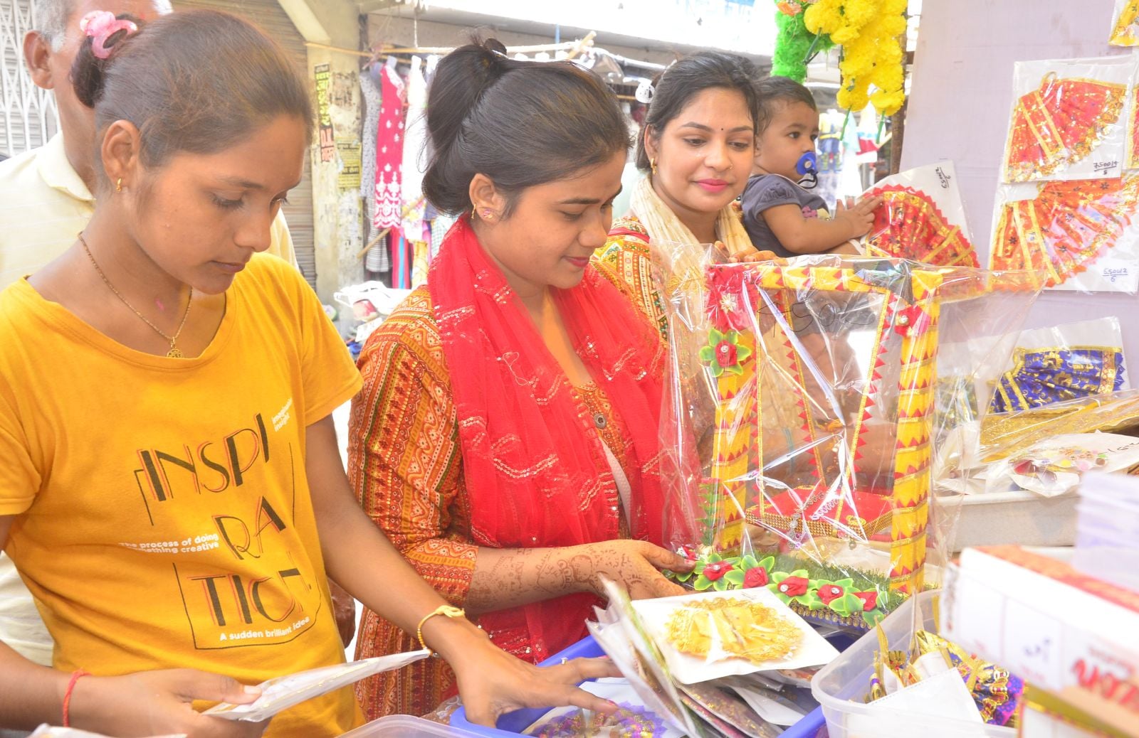 दुकान पर राधा-कृष्ण के वस्त्र पंसद करती महिलाएं। संवाद दुकान पर राधा-कृष्ण के वस्त्र पंसद करती महिलाएं। संवाद