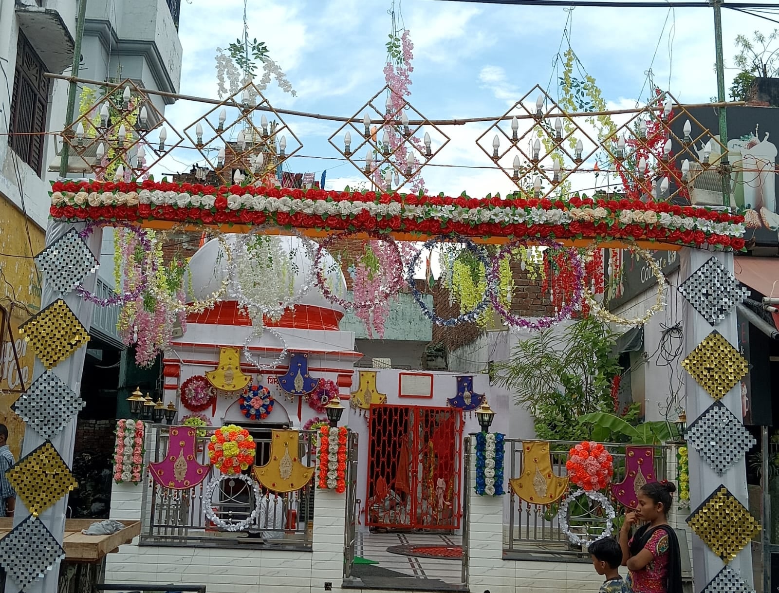 पीलीभीत में श्रीकृष्ण जन्माष्टमी पर्व पर शहर की स्टेडियम रोड पर सजी एक दुकान पर समान खरीदते लोग